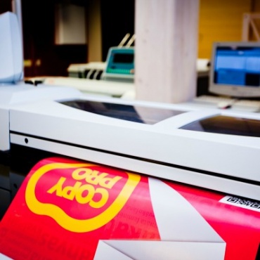 Lielformāta fotogrāfijas drukas process tipogrāfijā, fonā monitori