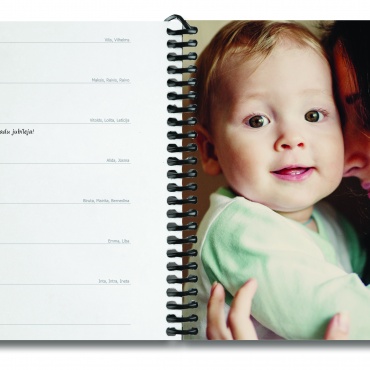 plānotājs metāla spirālē atvērumā - kreisajā lapā nedēļas dienas ar datumiem un vietu piezīmēm, labajā - foto ar māti un bērnu